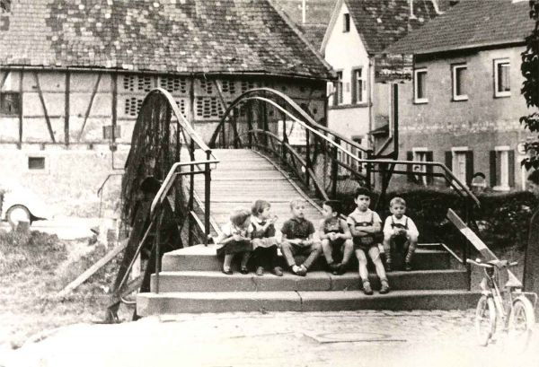 Die Boxerbrücke kurz nach dem Zweiten Weltkrieg. Kinder sitzen auf den Brückenstufen.